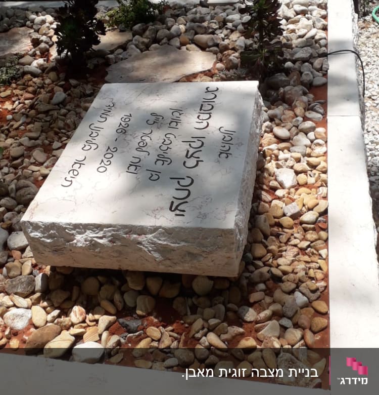 מצבות עם כיתוב בעברית ואבנים קטנות מסביב